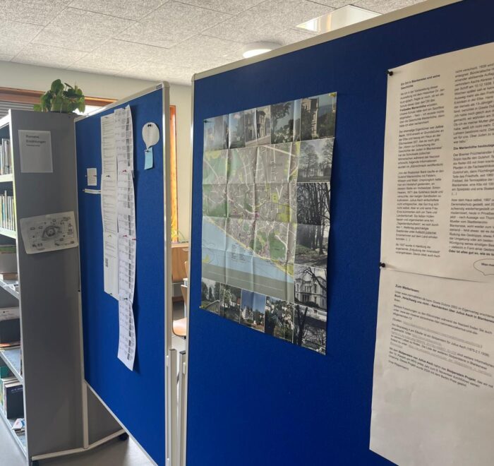 Eine blaue Wand mit einem Stadtplan und Informationsblättern in einem Innenraum.