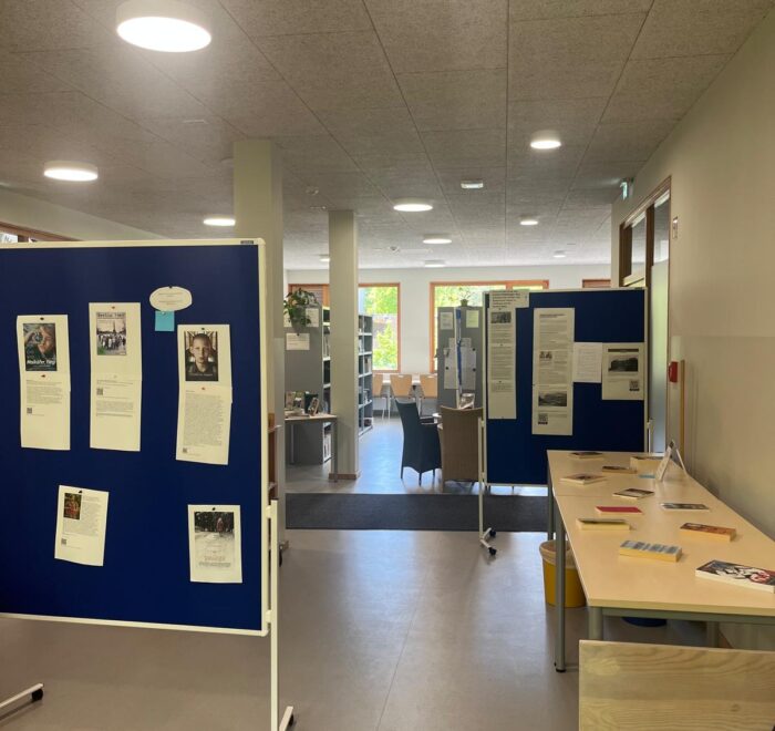 Bürobereich mit blauen Informationswänden und Tischen für die Nutzung durch Mitarbeiter.