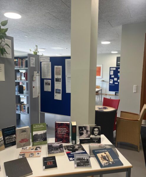 Ein Tisch mit verschiedenen Büchern und Dokumenten in einer Bibliothek.