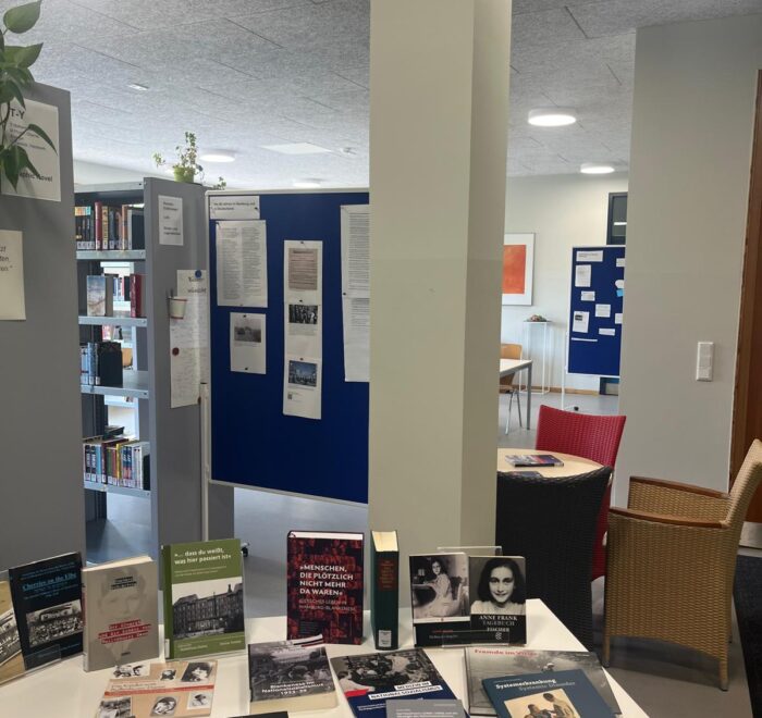 Ein Tisch mit verschiedenen Büchern und Dokumenten in einer Bibliothek.