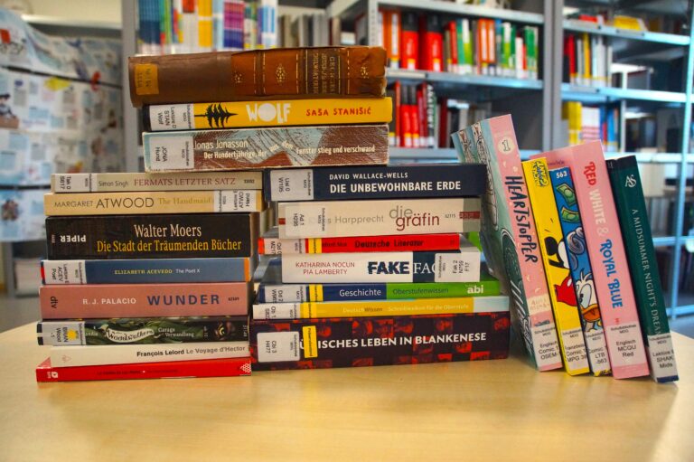 Zwei Stapel Bücher auf einem Tisch in einer Bibliothek.