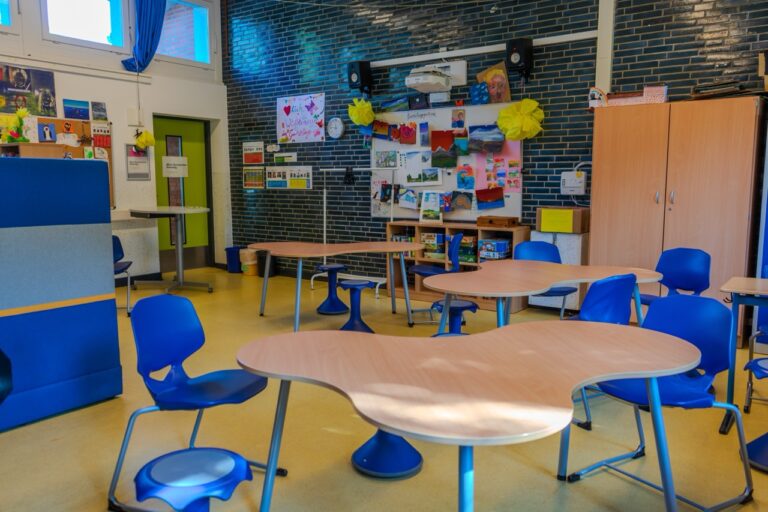 Moderner Klassenraum mit bunten Möbeln, Kunstwerken und Dekorationen an den Wänden.
