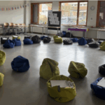 Alt-Text: Leckere Snacks auf einem Tisch, umgeben von bequemen Sitzsäcken in einem hellen Raum.