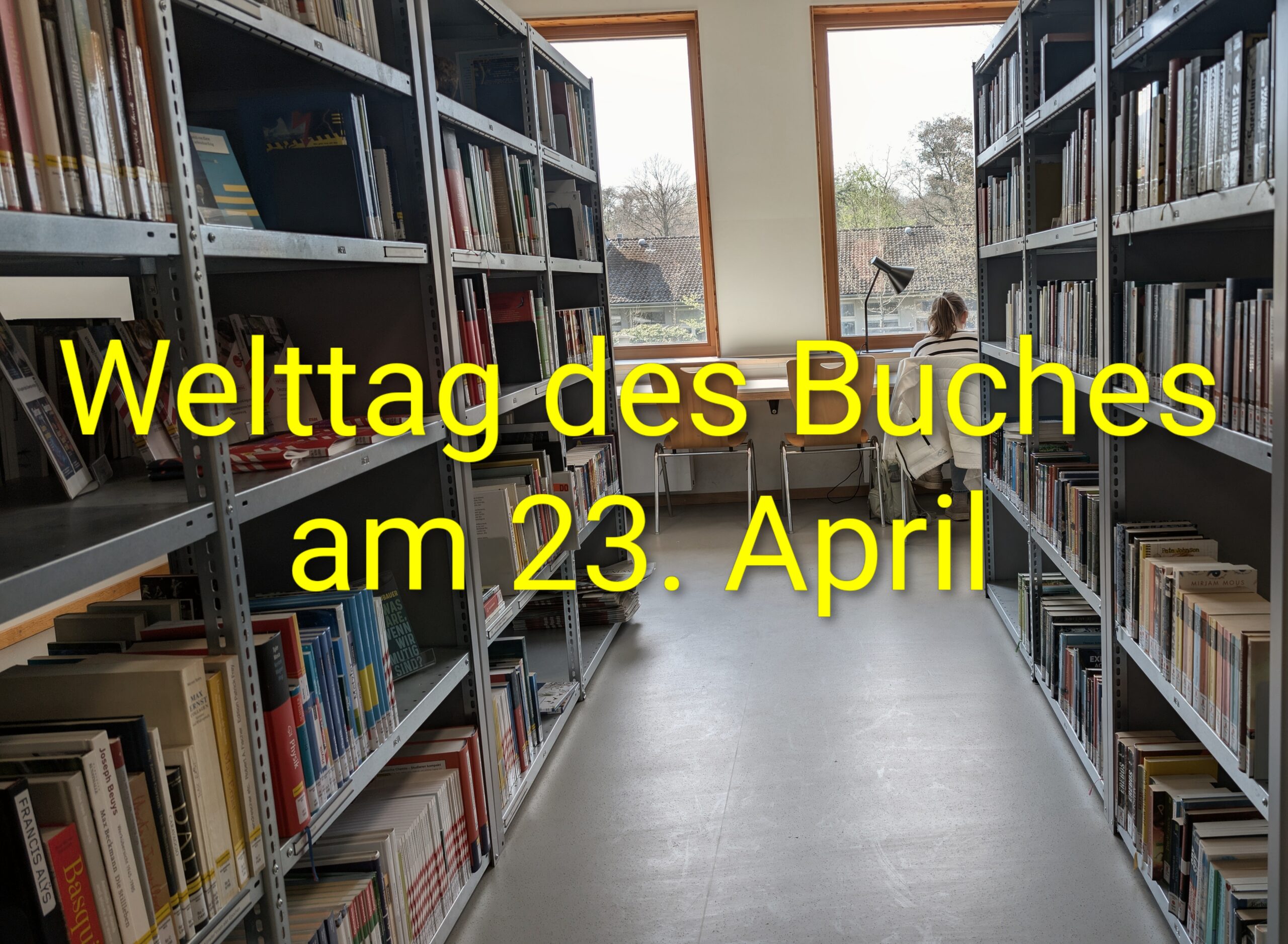 Eine Person sitzt an einem Tisch in einer Bibliothek, umgeben von Bücherregalen.